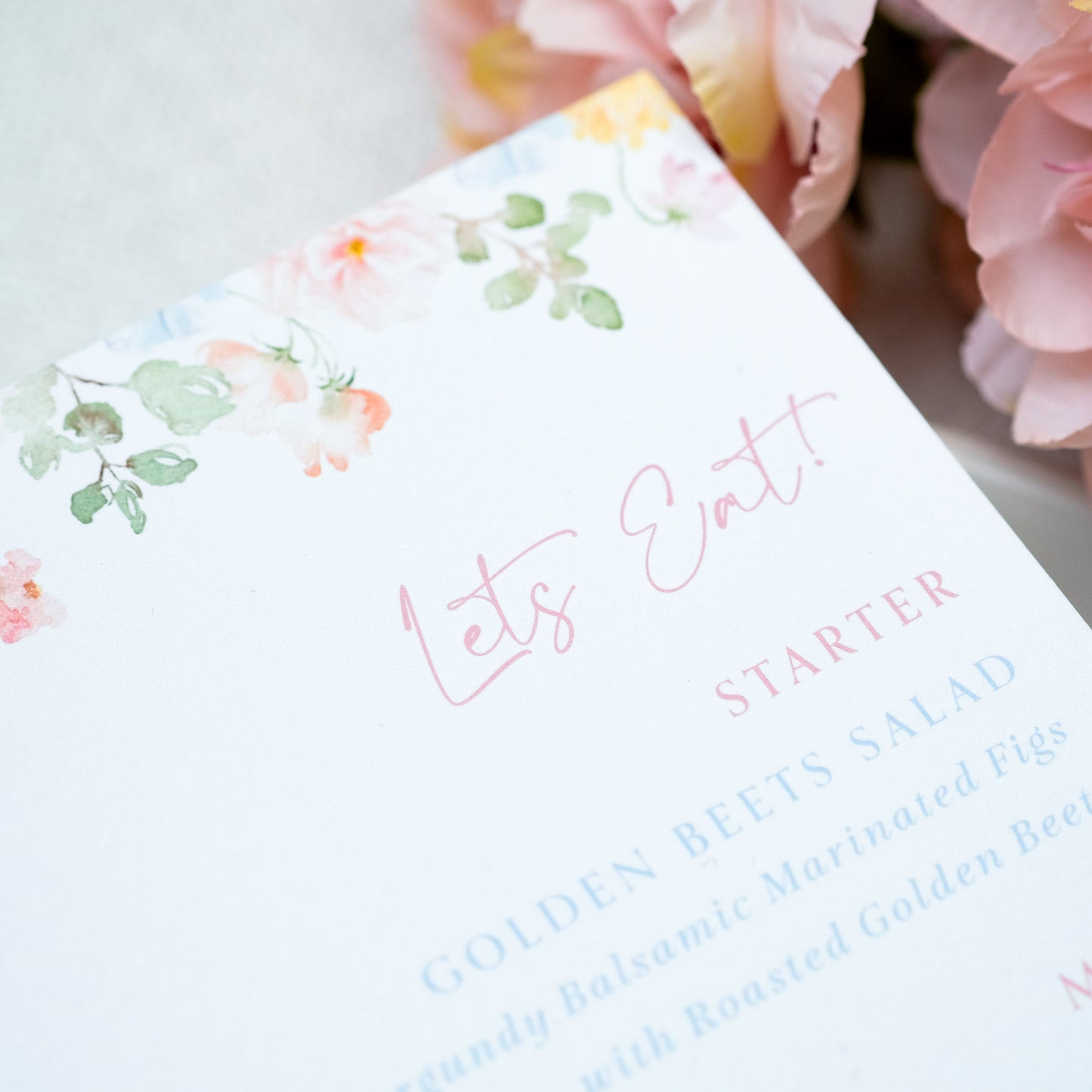 Wedding menu with pink floral detail and guest name