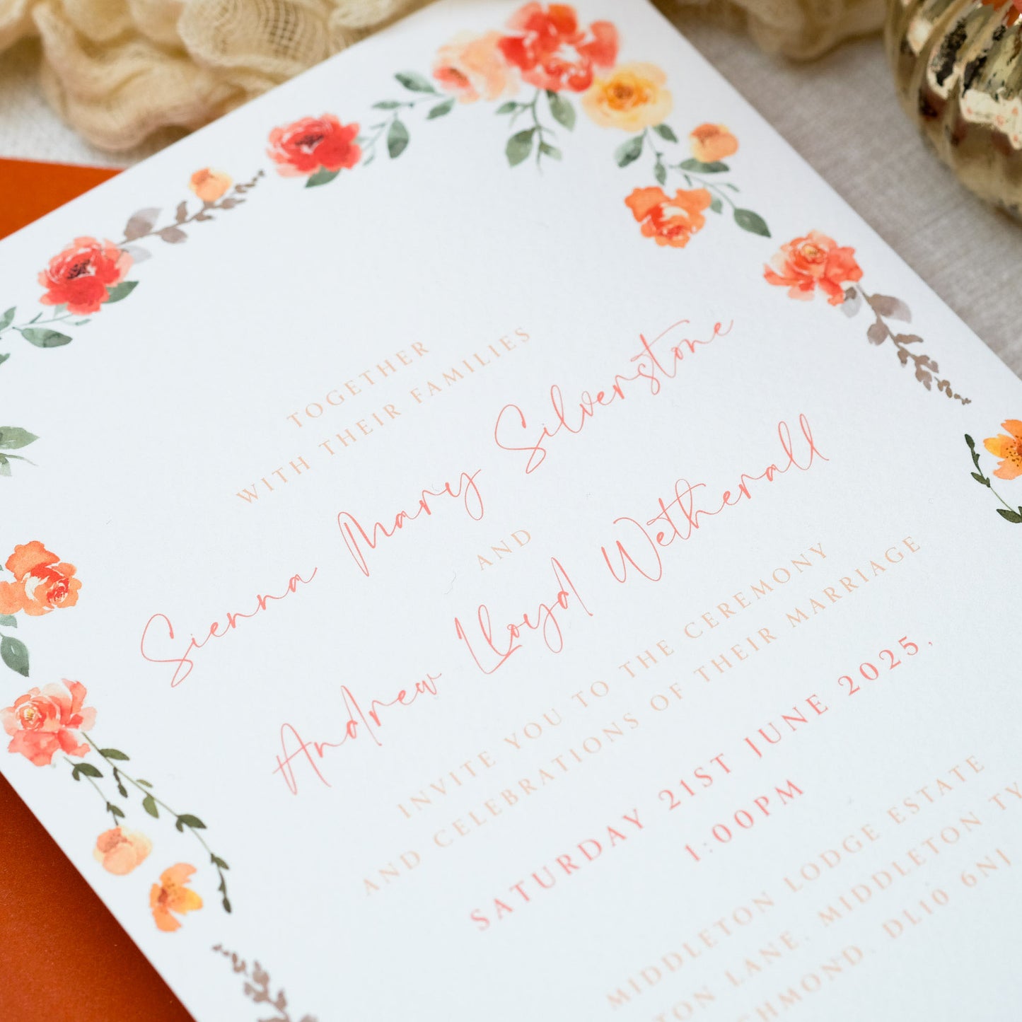 Wedding invitation with orange painterly wildflower border and orange guests names