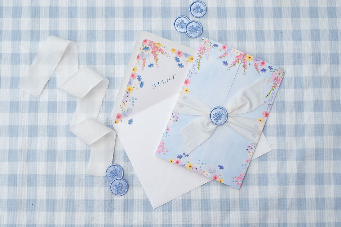 folded wildflower wedding invitation with envelope liner, ribbon and wax seals