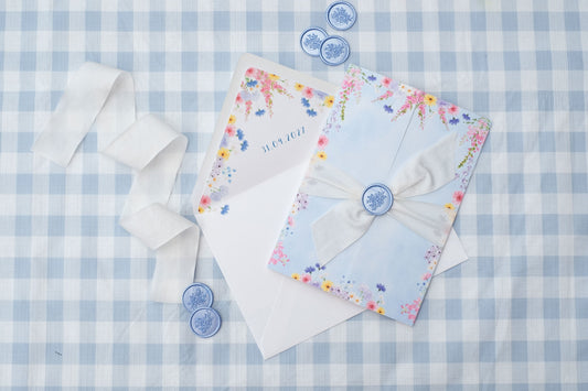 folded wildflower wedding invitation with envelope liner, ribbon and wax seals