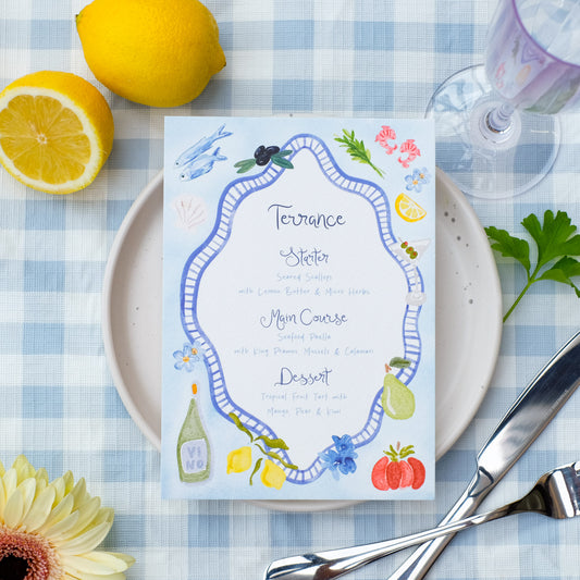 Hand painted wedding menu with blue border and watercolour illustrations of lemons, fish, shrimps and olives