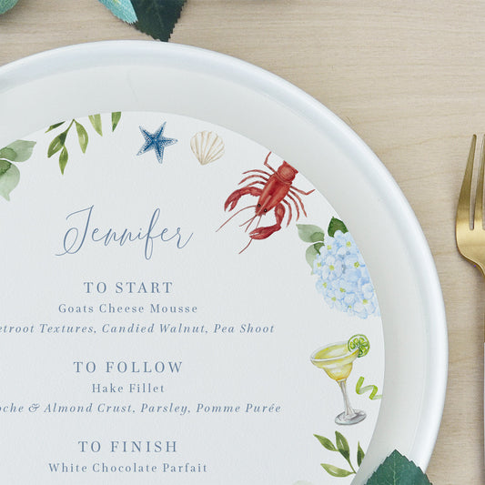 Round coastal wedding menu with lobsters and blue hydrangeas customised with guest name
